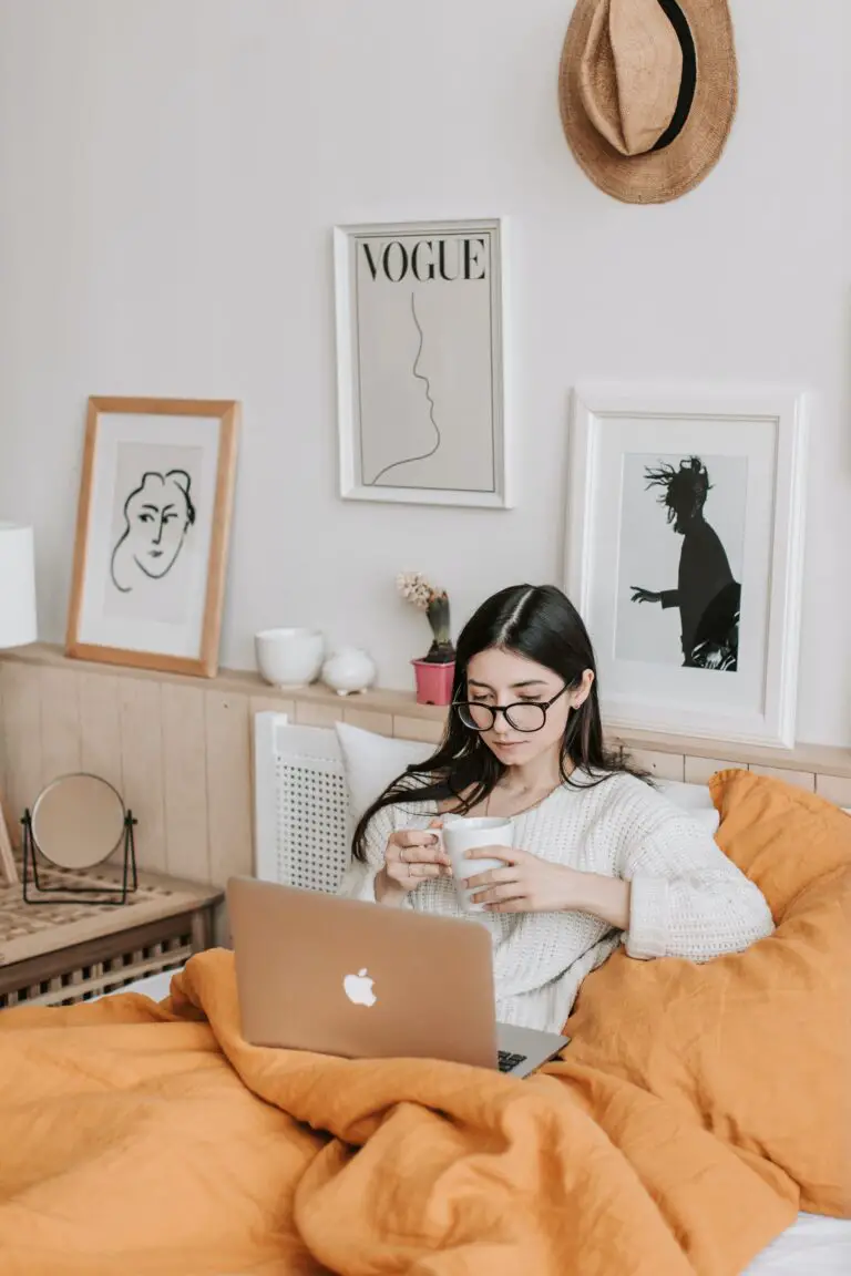 Woman Having Coffee And Using Laptop In Bed, searching for solutions to bed bug bites